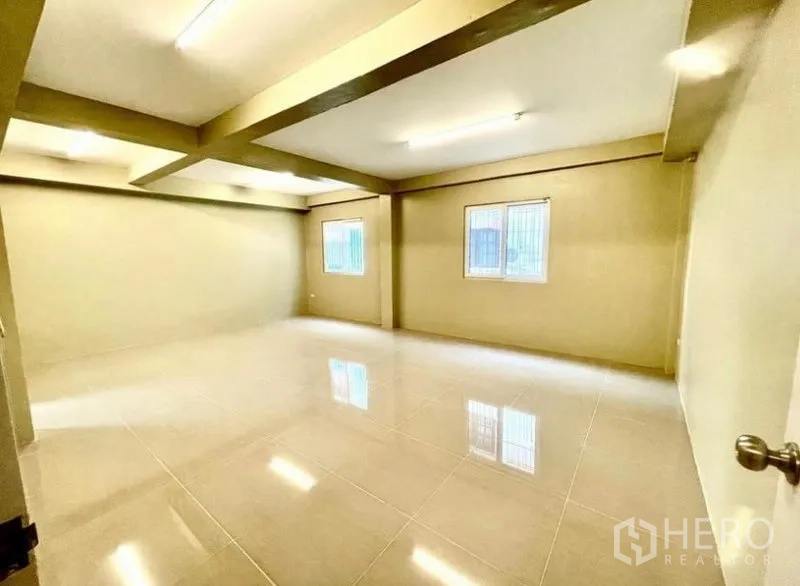 Townhouse for rent - Oversized multipurpose room with multiple windows and bright lighting.