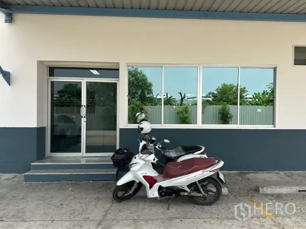 โรงงาน ให้เช่าในBang Phli, Samut Prakan - ทางเข้าออฟฟิศหน้าตึก ประตูกระจกบานเลื่อนและหน้าต่าง ใต้กันสาด มีรถจักรยานยนต์จอด