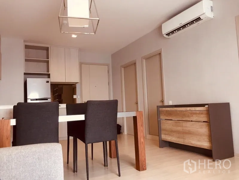 คอนโด ให้เช่าในKhlong Toei, Bangkok - พื้นที่นั่งเล่น–ทานอาหารแบบโอเพ่นแปลน พร้อมแอร์ โต๊ะกินข้าว และตู้ลิ้นชักลายไม้