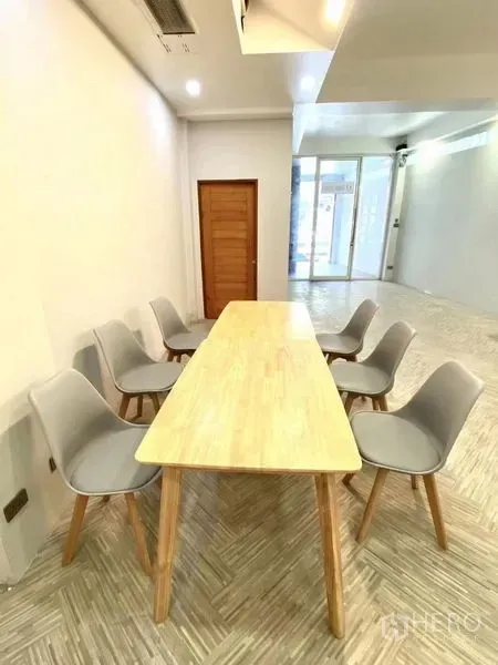 พื้นที่ขายปลีก ให้เช่าในWatthana, Bangkok - โต๊ะประชุมยาวพร้อมเก้าอี้สีเทา 6 ตัว ข้างประตูกระจกของหน้าร้านที่โปร่งสว่าง