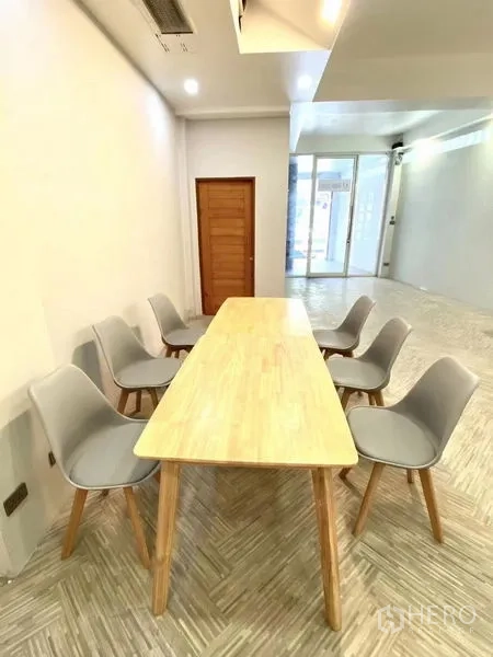 พื้นที่ขายปลีก ให้เช่าในWatthana, Bangkok - โต๊ะประชุมยาวพร้อมเก้าอี้สีเทา 6 ตัว ข้างประตูกระจกของหน้าร้านที่โปร่งสว่าง