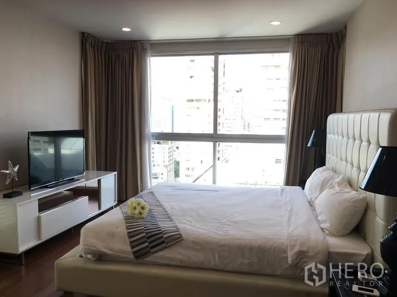 คอนโด ให้เช่าในPathum Wan, Bangkok - ห้องนอนใหญ่ เตียงหัวบุนวม ตู้วางทีวี และหน้าต่างบานกว้างวิวเมือง