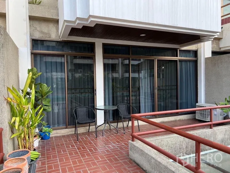 Townhouse for sale in Suan Luang, Bangkok - Terrace view showing sliding glass frontage and a small bistro set beside planters.