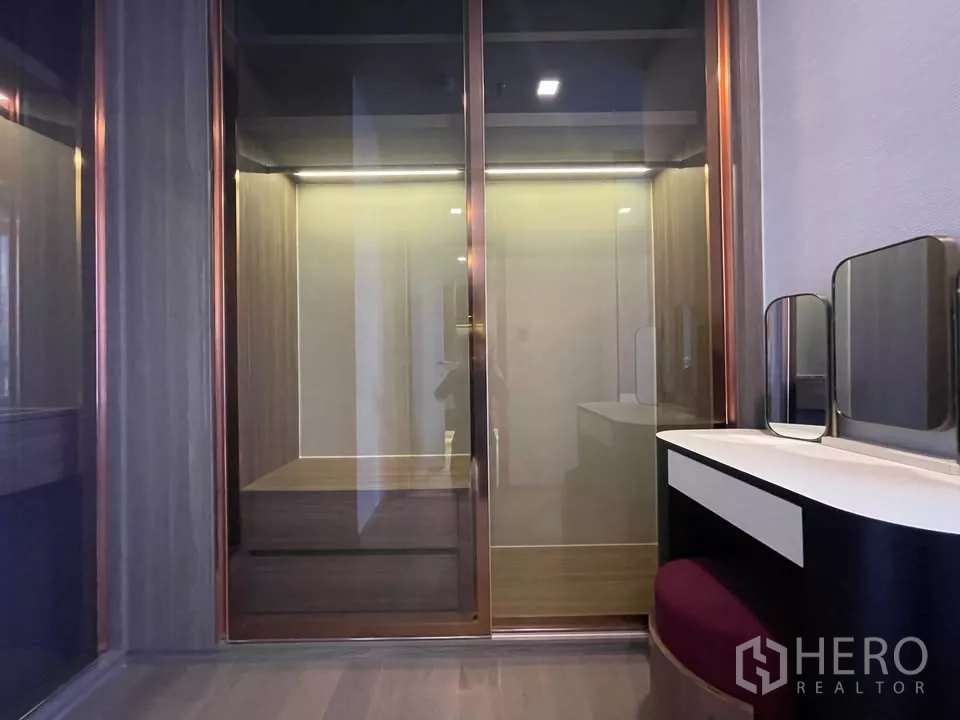 Condominium for rent in Watthana, Bangkok - Walk-in wardrobe with sliding glass doors and dressing table with stool.