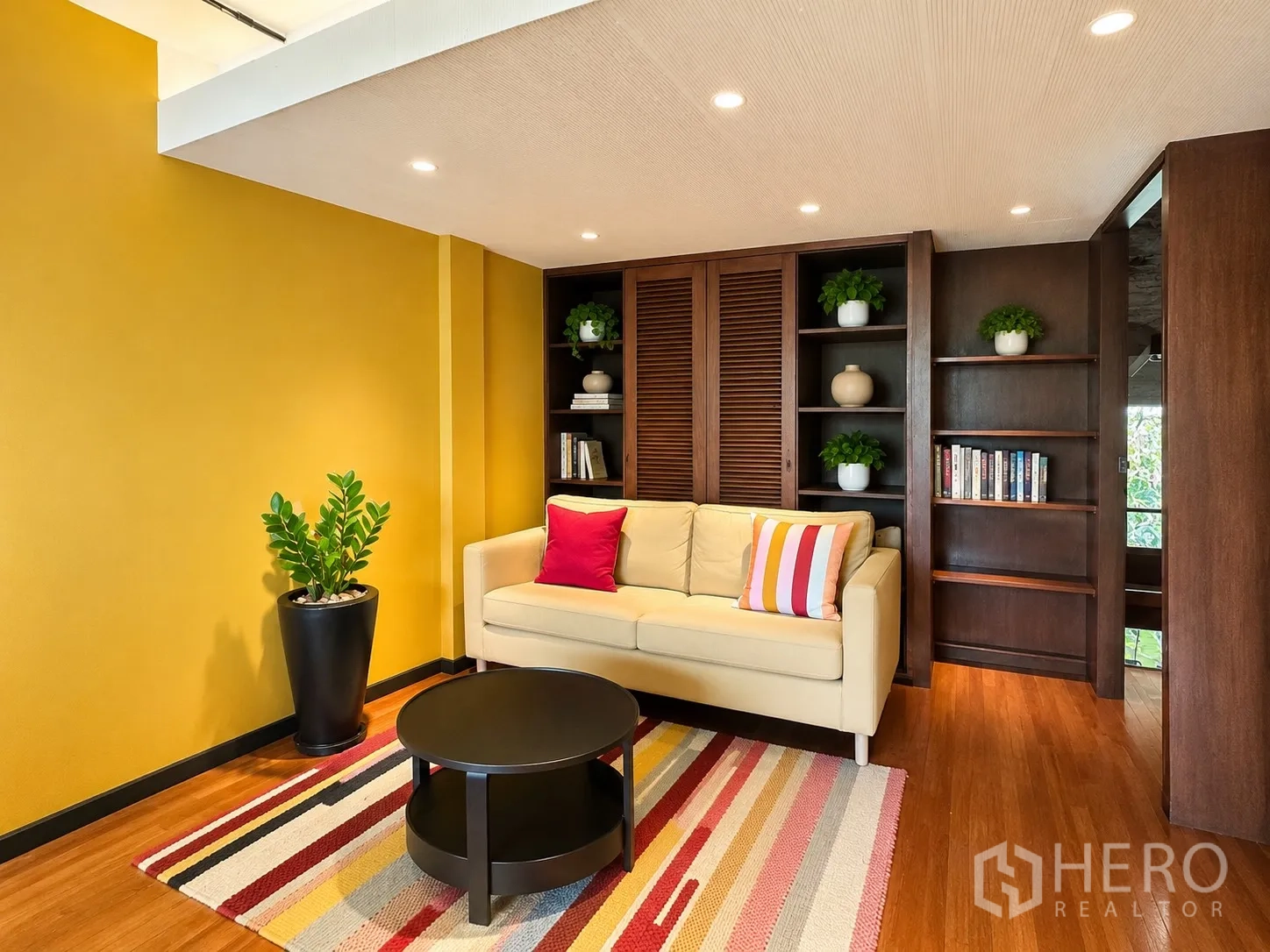 办公室 for rent in Phaya Thai, Bangkok - 黄色墙面休闲区，米色沙发与内嵌书柜。