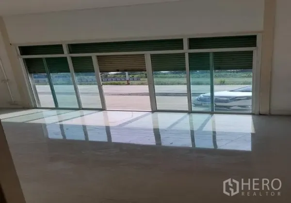 工厂 出租在Pathum Thani - 明亮的前置办公区，玻璃推拉门配高位卷帘门，面向道路。