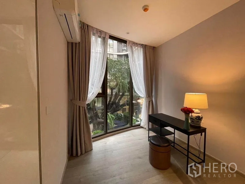 คอนโด ให้เช่าในKhlong Toei, Bangkok - ห้องนอนหรือมุมทำงาน มีโต๊ะและโคมไฟ หน้าต่างเต็มบานมองเห็นต้นไม้