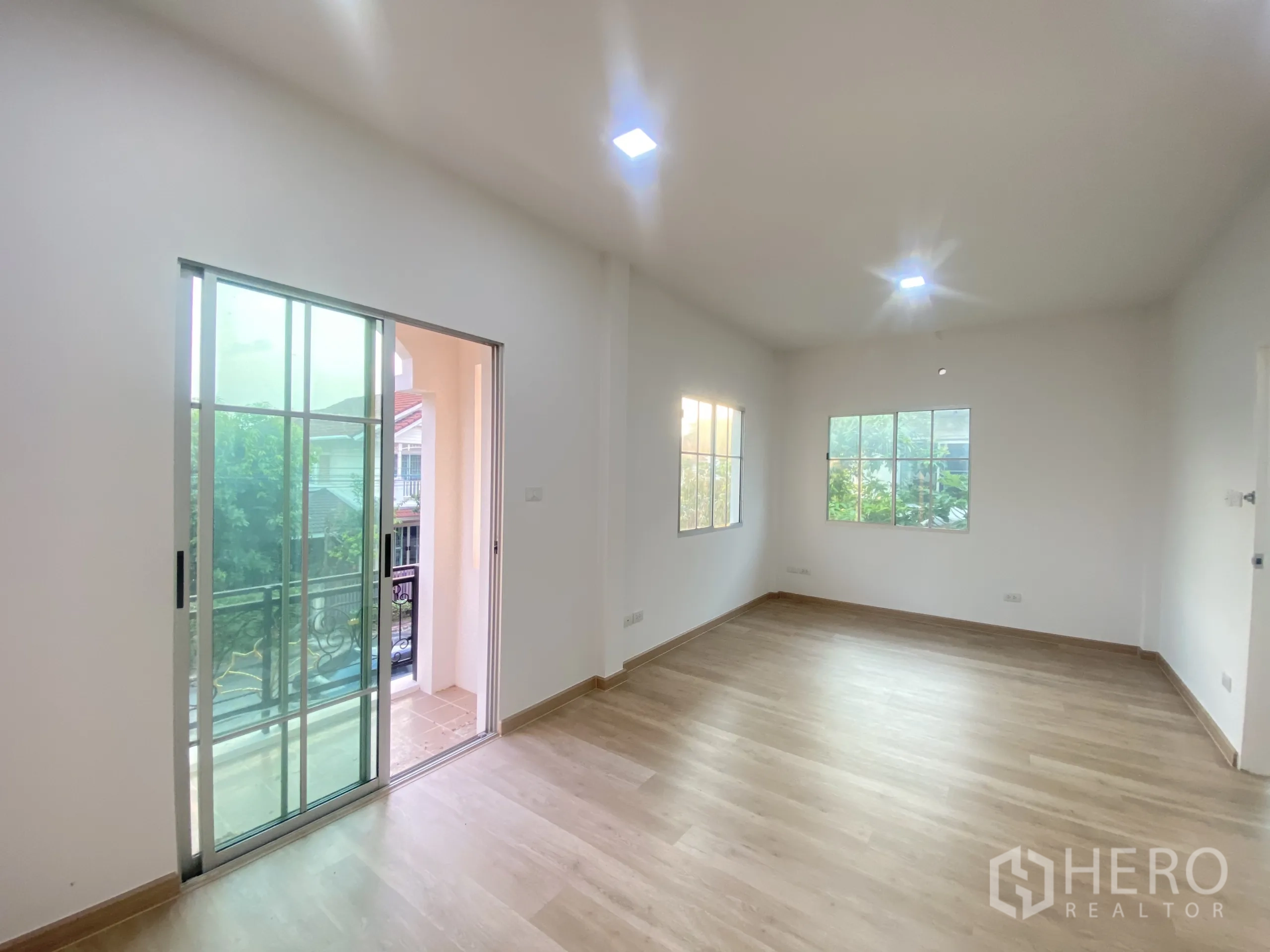 Detached House for sale in Nonthaburi - Large master bedroom with balcony access and wood floors.