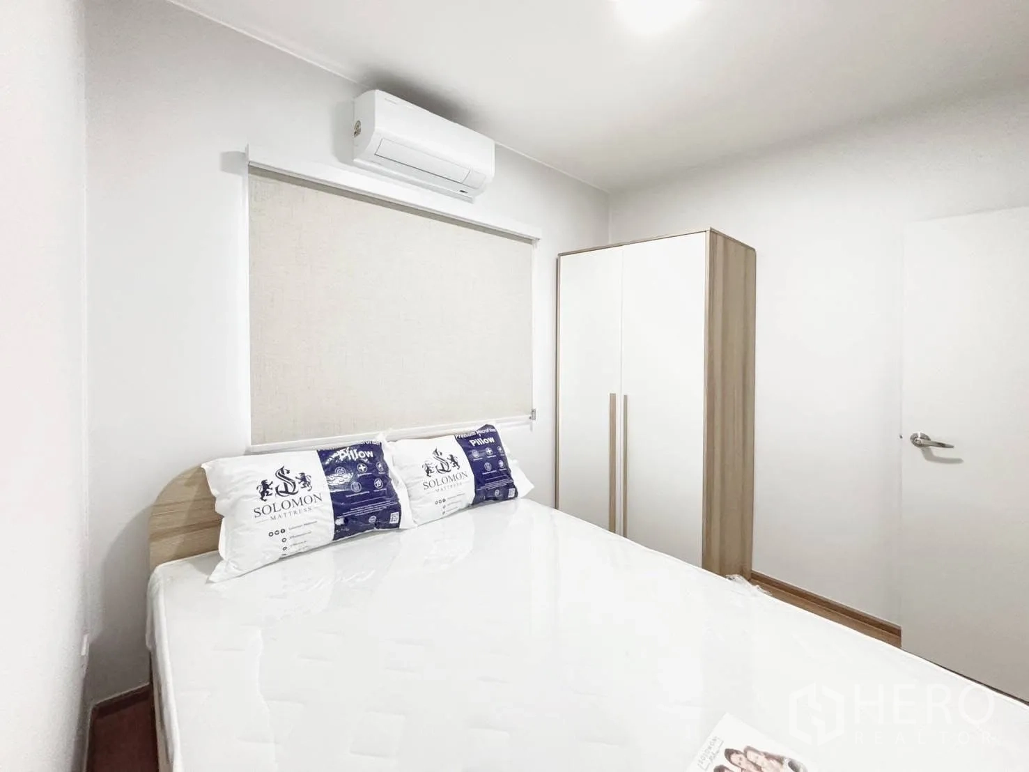 ทาวน์เฮาส์ for rent in Bang Phli, Samut Prakan - ห้องนอนพร้อมเตียง ตู้เสื้อผ้า ม่านม้วน และเครื่องปรับอากาศติดผนัง.