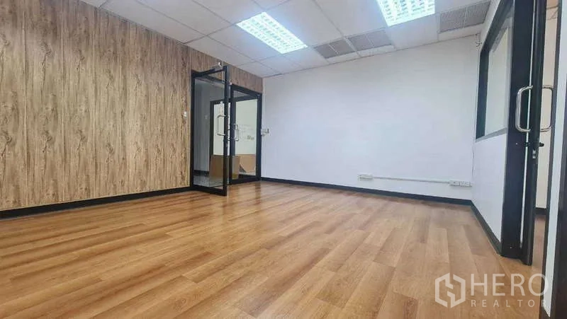 สำนักงาน ให้เช่าในKhlong Toei, Bangkok - ห้องสำนักงานโล่งสว่าง พื้นลามิเนตลายไม้ ประตูกระจก และไฟฝ้าตะแกรง