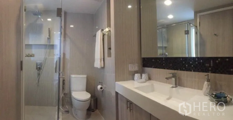 คอนโด ให้เช่าหรือขายในWatthana, Bangkok - ห้องน้ำสมัยใหม่ มีฝักบัวแบบกระจกกั้น โถสุขภัณฑ์ และเคาน์เตอร์อ่างยาวพร้อมกระจกบานใหญ่