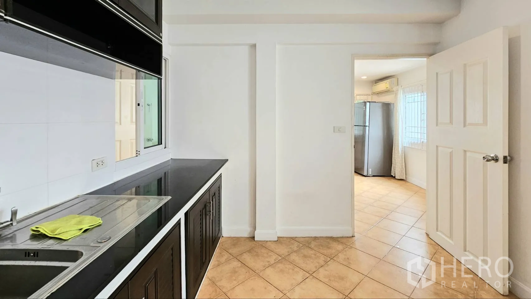 Detached House for rent in Saphan Sung, Bangkok - Pantry area with black countertops, sink, and doorway to fridge space.