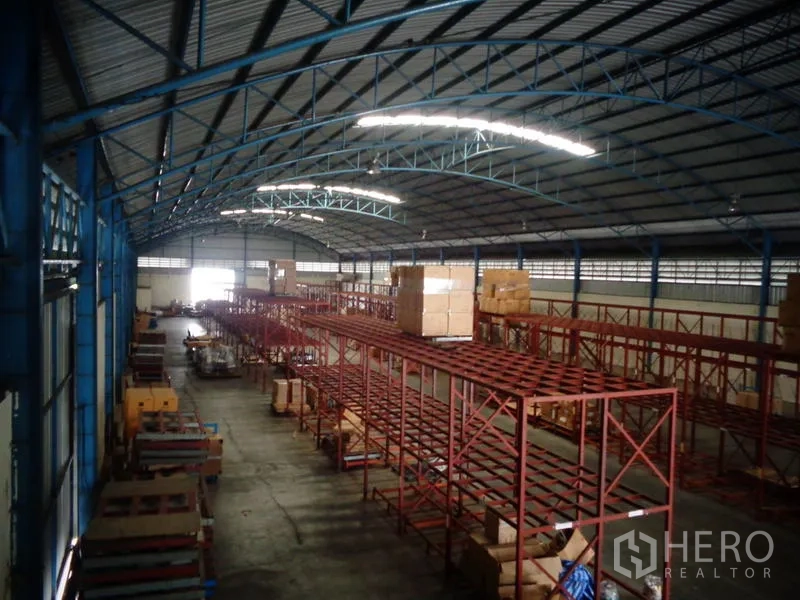 Warehouse for rent or sale in Lat Lum Kaeo, Pathum Thani - Elevated view of multiple racking rows and skylit arched roof in the storage hall.
