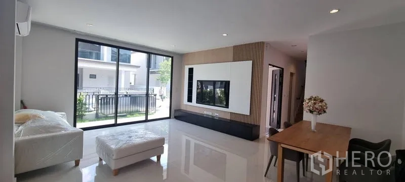 บ้าน ให้เช่าในSaphan Sung, Bangkok - ห้องนั่งเล่นเปิดโล่งพร้อมประตูกระจกบานใหญ่และผนังทีวีบิวท์อิน