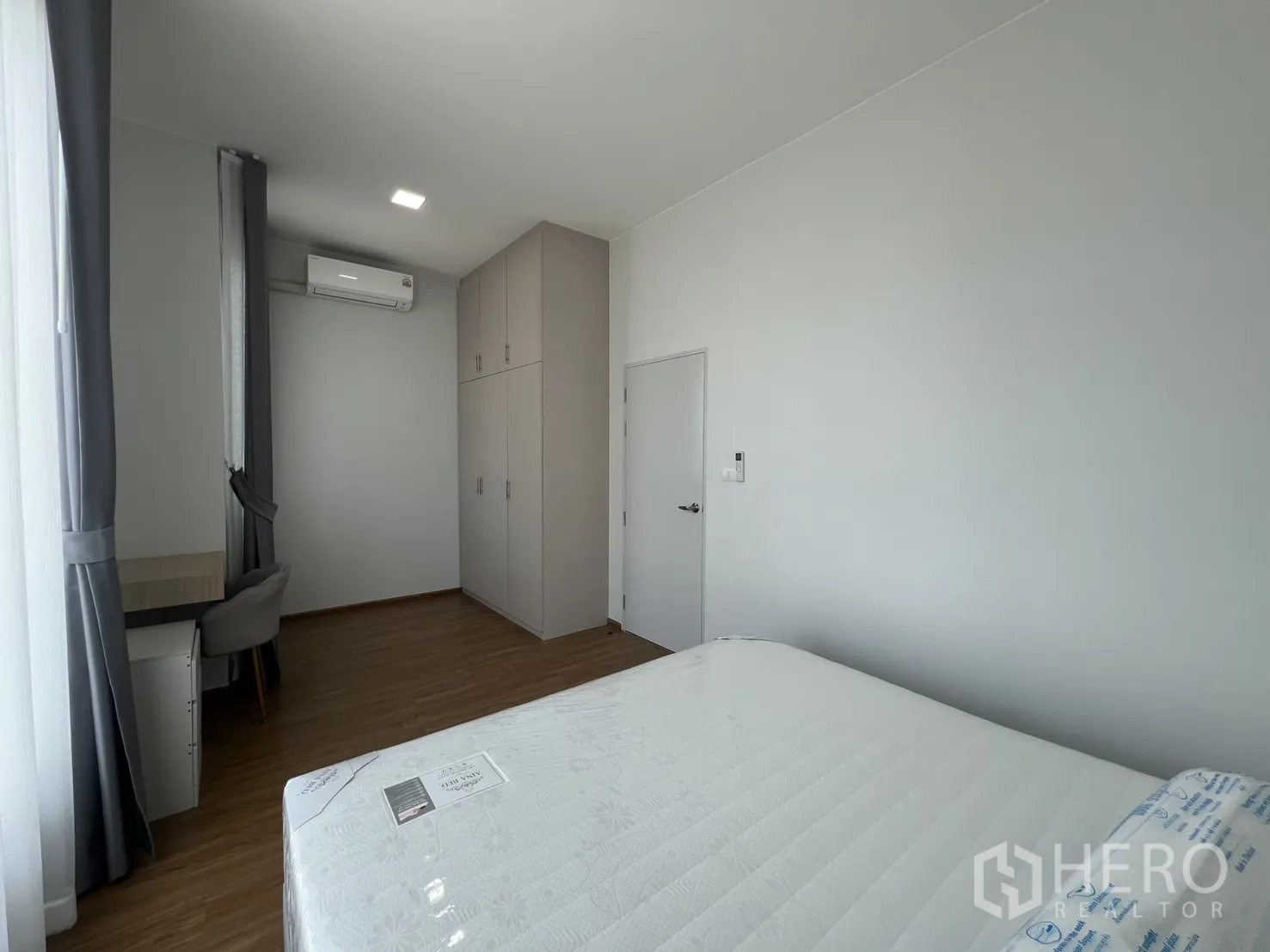 Townhouse for rent in Bang Phli, Samut Prakan - Master bedroom angle showing bed, tall wardrobes and work desk.