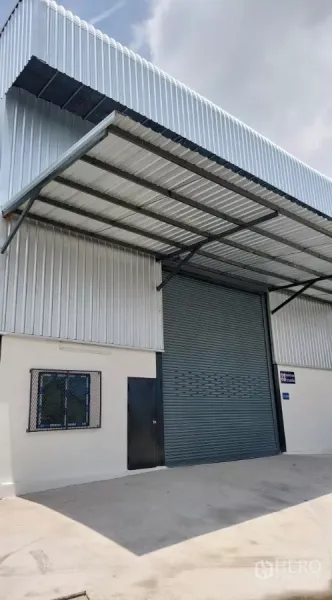 货栈 出租在Khlong Toei, Bangkok - 新建金属外墙仓库外观，带大型卷闸门与雨棚。