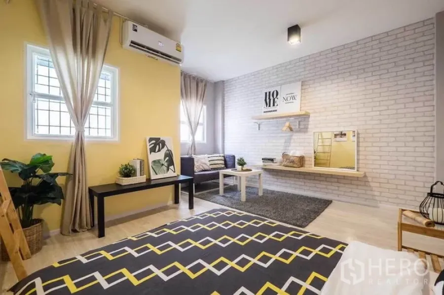 บ้าน ให้เช่าในKhlong Toei, Bangkok - ห้องนอนสว่าง พรมลายก้างปลา ผนังอิฐโชว์ มุมนั่งเล่น และเครื่องปรับอากาศ
