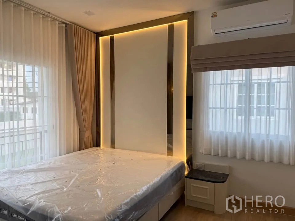 บ้านแฝด for rent in Mueang Samut Prakan, Samut Prakan - ห้องนอนมีหน้าต่างบานใหญ่ ผนังหัวเตียงไฟซ่อน และเครื่องปรับอากาศ