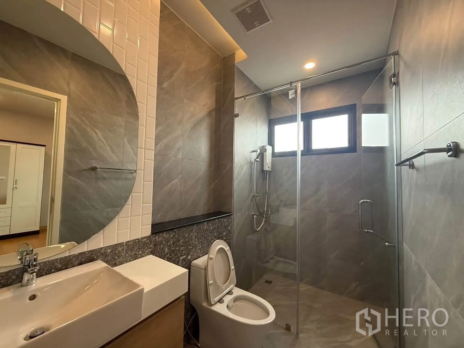 独栋房屋 for rent in Suan Luang, Bangkok - 卫浴带步入式玻璃淋浴间和大型圆镜。