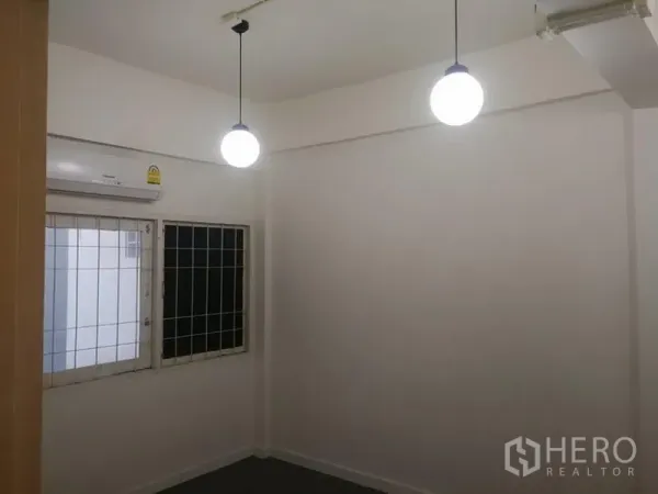 ทาวน์เฮาส์ ให้เช่าในKhlong Toei, Bangkok - ห้องนอนมีโคมไฟแขวนสองดวง หน้าต่างเหล็กดัด และแอร์ผนัง