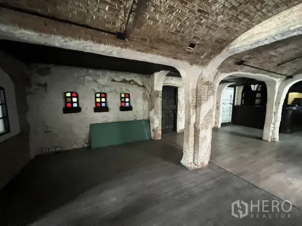 零售空间 出租在Watthana, Bangkok - 开放式大厅，砖柱与拱顶天花，小型彩色玻璃窗点缀。