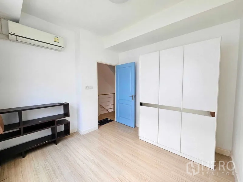 สำนักงานที่บ้าน ให้เช่าหรือขายในSuan Luang, Bangkok - ห้องนอนพร้อมเครื่องปรับอากาศ ตู้เสื้อผ้าสีขาว และพื้นไม้