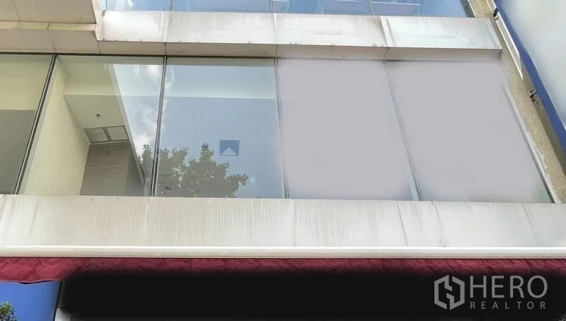 零售空间 出租 - 上层零售立面，落地玻璃窗与红色遮阳篷。