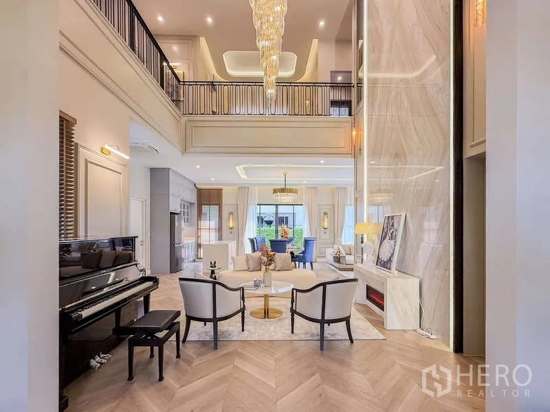 Detached House for rent or sale in Bang Kapi, Bangkok - Double-height living room with dramatic chandelier, mezzanine and a piano.