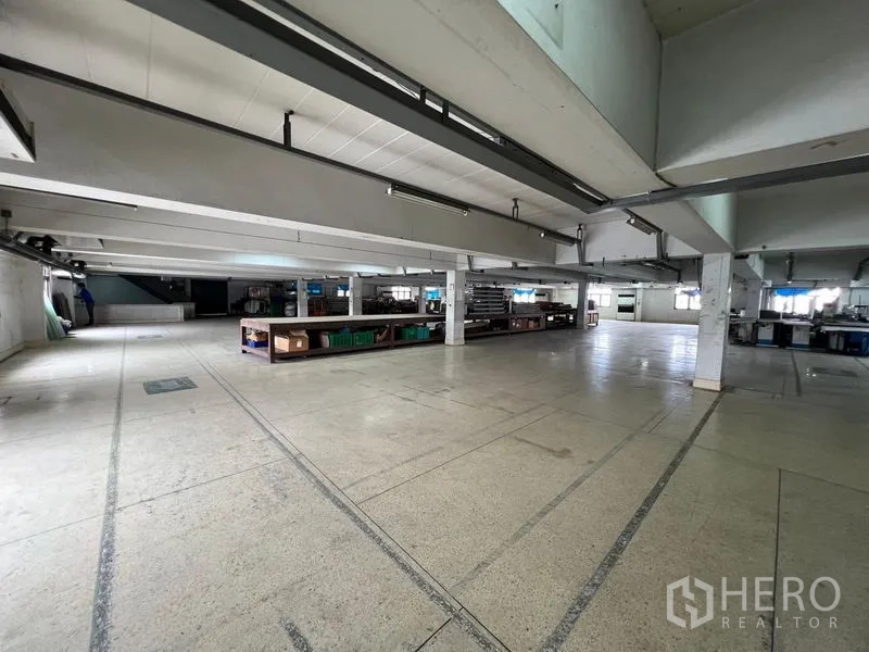 Warehouse for rent in Bang Kapi, Bangkok - Open-plan warehouse floor with concrete slab, columns, and strip lighting suitable for storage and assembly.