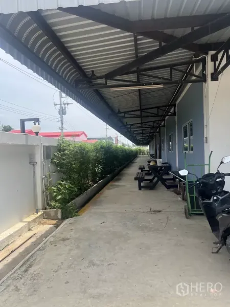 โรงงาน ขายในLat Lum Kaeo, Pathum Thani - ทางเดินมีหลังคากันสาด โต๊ะพักผ่อน และแนวสวนข้างอาคาร