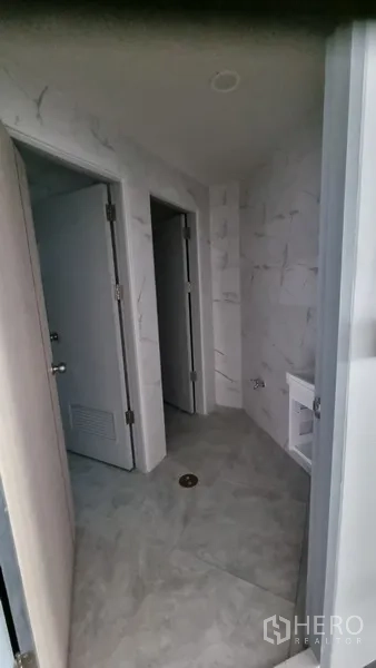 อาคารพาณิชย์ ให้เช่าในKhlong Toei, Bangkok - โถงห้องน้ำปูกระเบื้องลายหินอ่อนโทนอ่อน พร้อมประตูหลายช่อง.