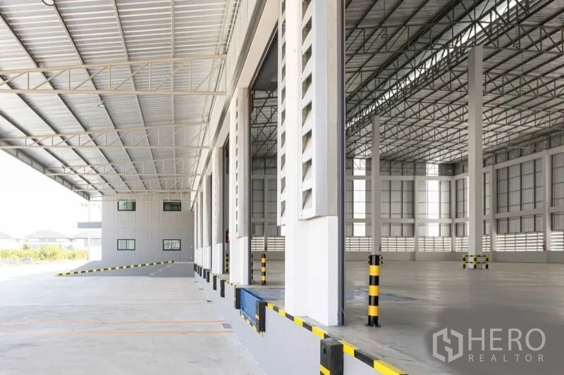 Warehouse for rent in Bang Bo, Samut Prakan - Covered loading platform with dock levelers and roller shutters beside the warehouse interior.