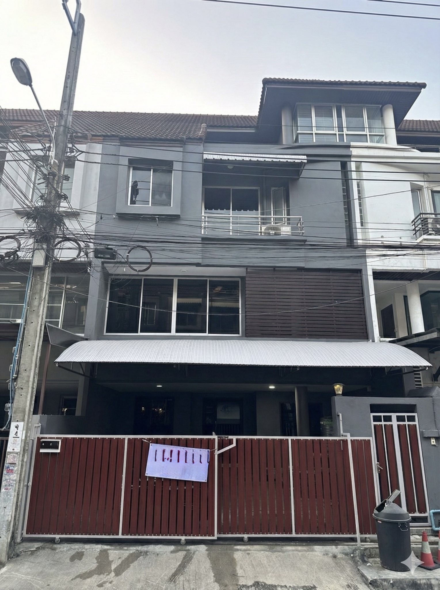 带办公室的家 出租在Wang Thonglang, Bangkok - 三层家庭办公楼外观，红色推拉门、雨篷与阳台。