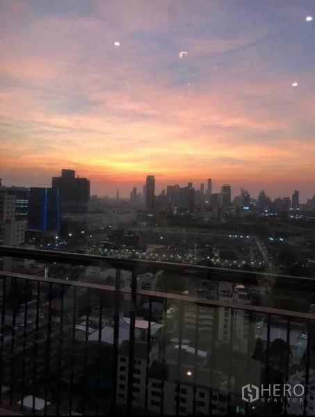 Condominium for sale in Khlong Toei, Bangkok - High-floor balcony view of Bangkok skyline at sunset from a Khlong Toei condo.