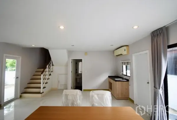 Detached House for rent in Prawet, Bangkok - Dining corner beside the staircase and compact pantry kitchen with window and air-conditioning.