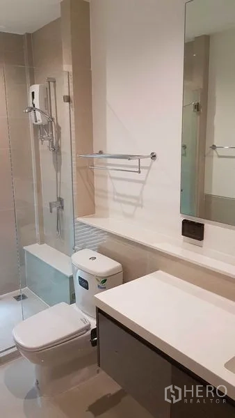 Detached House for rent in Prawet, Bangkok - Modern bathroom with glass-enclosed shower, vanity, and toilet.