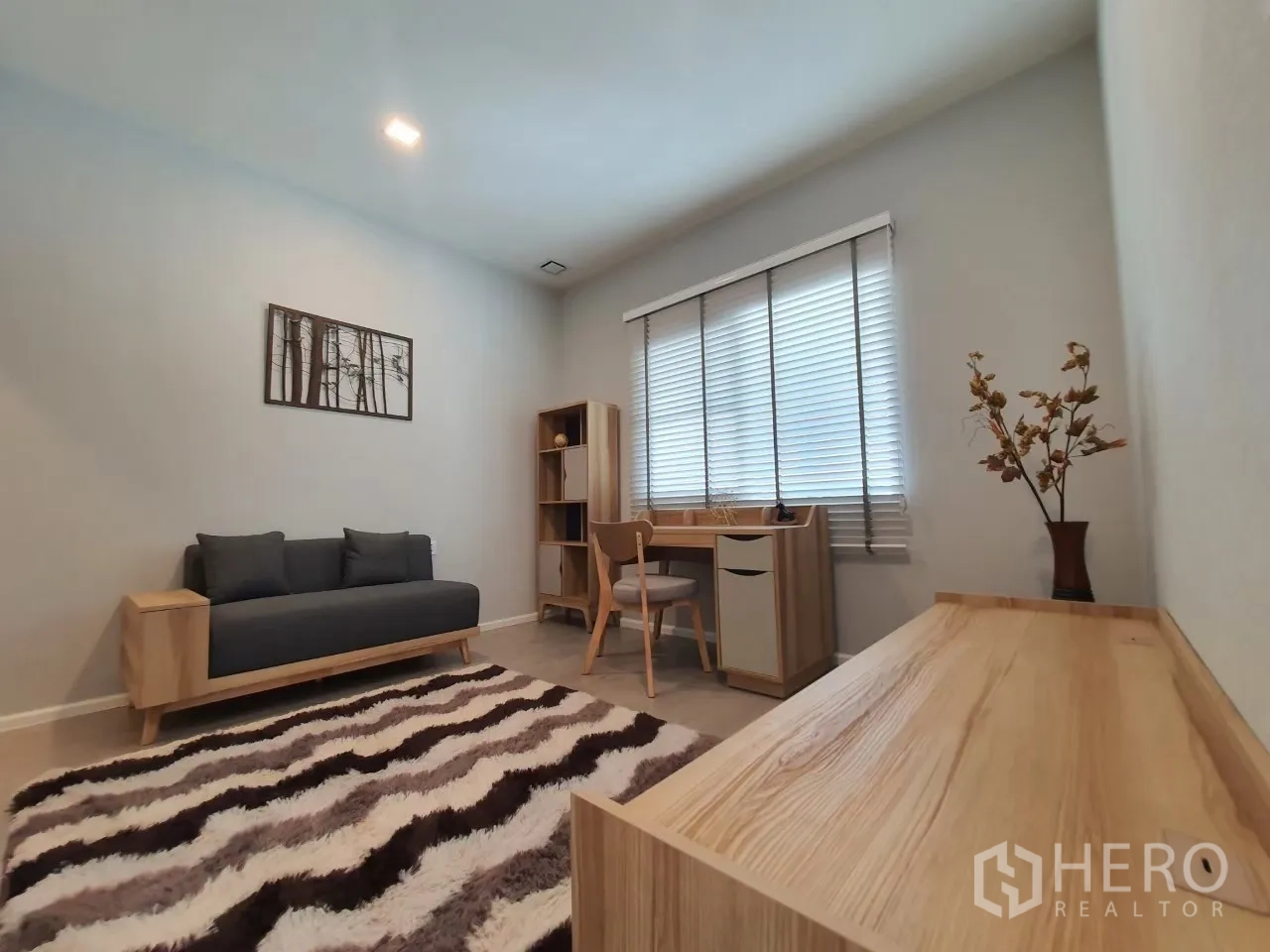 บ้าน ให้เช่าในPrawet, Bangkok - ห้องอเนกประสงค์ตกแต่งเป็นห้องทำงานพร้อมโซฟา โต๊ะ และพรมลาย.