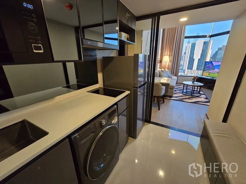 公寓 出租 - 狭长现代厨房，感应炉、洗烘一体机，望向客厅与城市景观