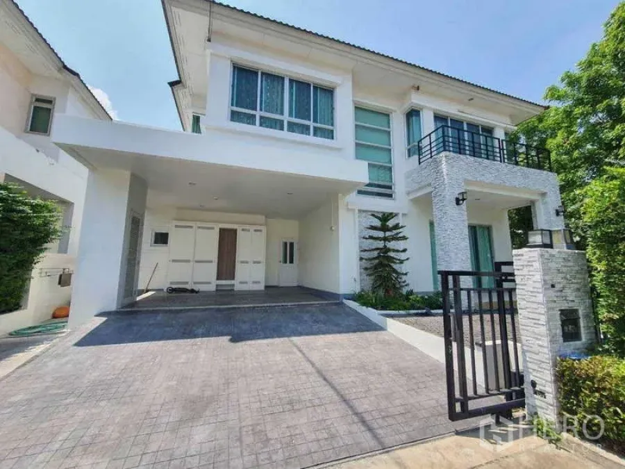 Detached House for rent in Saphan Sung, Bangkok - Front exterior of a white two‑storey home with gate and covered parking.