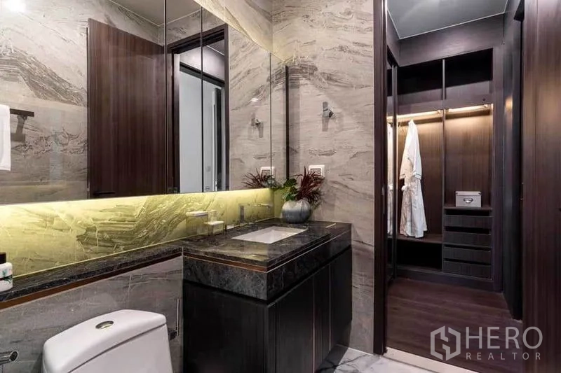 公寓 出租在Watthana, Bangkok - 带背光镜柜的浴室，通向步入式衣帽间。