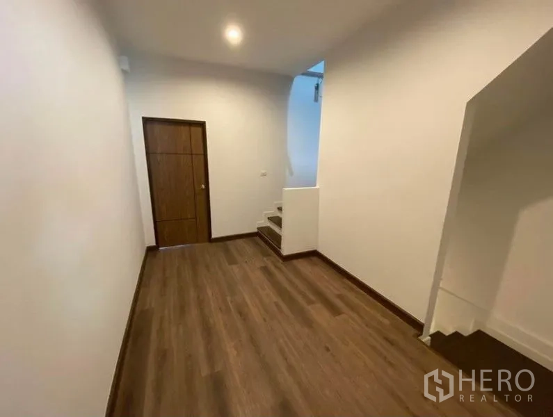 联排别墅 出租在Bang Na, Bangkok - 楼层走廊，木地板，储物门与通往上层的楼梯