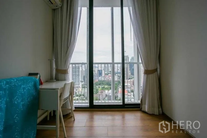 คอนโด ขายในKhlong Toei, Bangkok - ห้องนอนรองหรือห้องทำงานพร้อมโต๊ะและหน้าต่างสูงมองเห็นวิวสกายไลน์