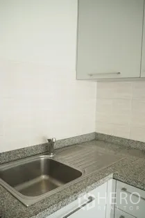 Condominium for rent in Pathum Wan, Bangkok - Close-up of stainless-steel sink and granite countertop in the compact kitchen.