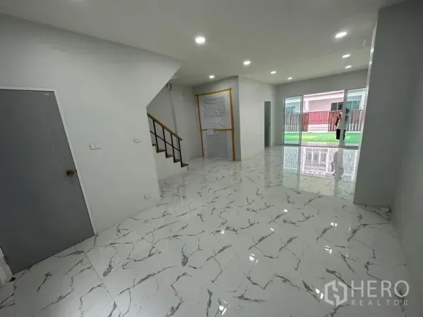 Home Office for rent or sale - Bright living and work area with staircase and large sliding glass doors opening to a small lawn courtyard.