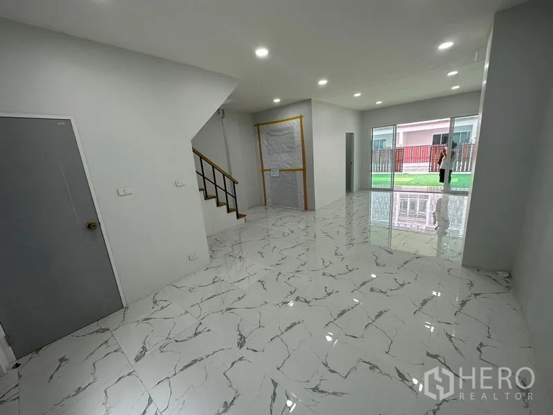 Home Office for rent or sale - Bright living and work area with staircase and large sliding glass doors opening to a small lawn courtyard.