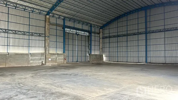 Warehouse for rent in Ban Pho, Chachoengsao - Clear-span warehouse space with insulated curved roof and clean concrete floor ready for storage.
