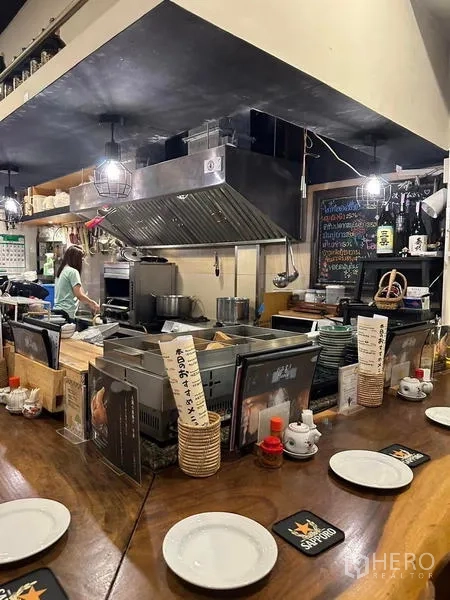 อาคารพาณิชย์ ให้เช่าหรือขายในWatthana, Bangkok - ครัวเปิดติดตั้งสำหรับร้านอาหาร มีฮูดดูดควันสแตนเลส ชุดอุปกรณ์ และไฟแขวน