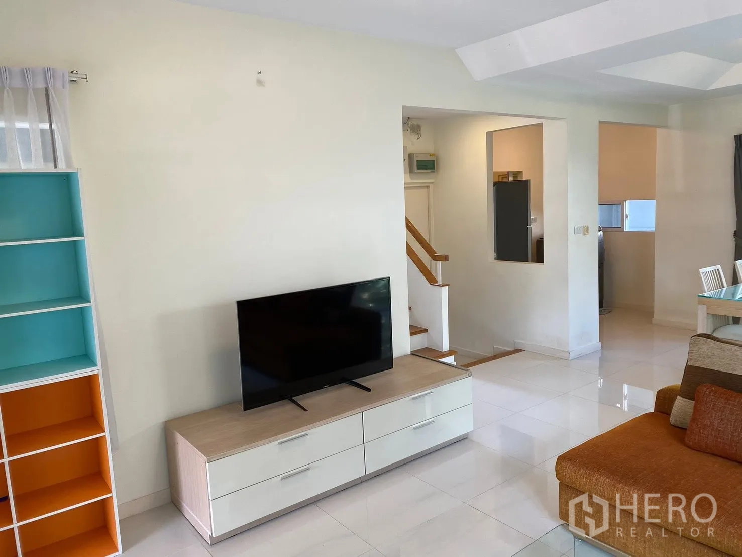 Detached House for rent in Prawet, Bangkok - Living area with TV console, sofa, and glossy tile floors.