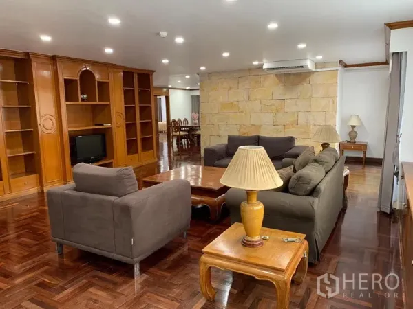 คอนโด ให้เช่าในWatthana, Bangkok - ห้องนั่งเล่นกว้างของ Liberty Park 1 พื้นปาร์เกต์ ตู้บิวต์อิน โซฟาสีเทา และผนังหินตกแต่ง ในเขตวัฒนา กรุงเทพฯ