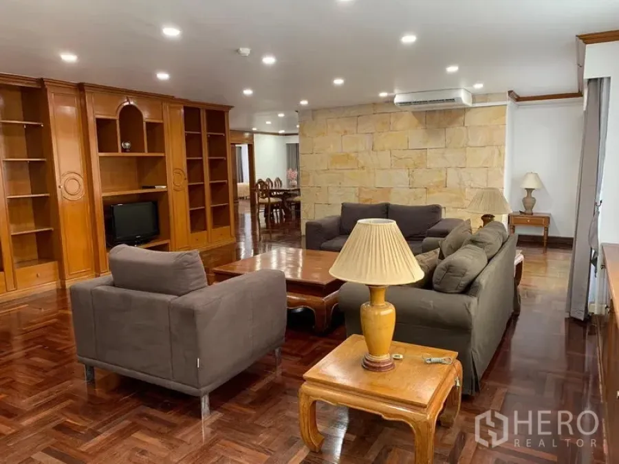 คอนโด ให้เช่าในWatthana, Bangkok - ห้องนั่งเล่นกว้างของ Liberty Park 1 พื้นปาร์เกต์ ตู้บิวต์อิน โซฟาสีเทา และผนังหินตกแต่ง ในเขตวัฒนา กรุงเทพฯ